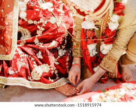 Indian groom putting the bridal toe ring at ritual ceremony