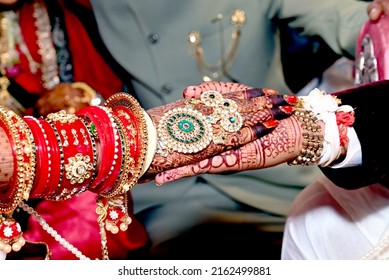 Indian Gujarati marriages are taking place

Hand in hand with each other

There is coconut in hand. The bride is sitting with both hands together. Hand bracelets are visible, beautiful mehndi is appea