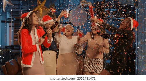 Indian happy attractive woman staff group standing together hold glass drink wine juice celebrate new year. Diverse cute smiling female colleague team talk dancing making fun joy enjoy festive season - Powered by Shutterstock