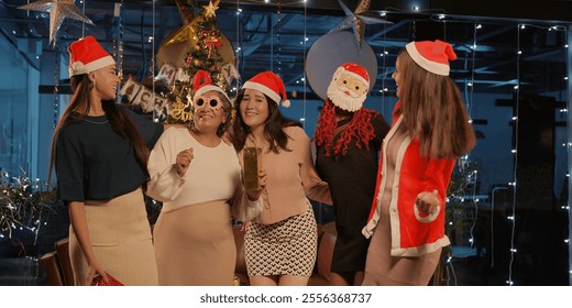 Indian happy attractive woman staff group standing together dancing make fun joy enjoy festive season. young adult smiling female colleague friend cute older lady hold gift celebrate merry Christmas - Powered by Shutterstock