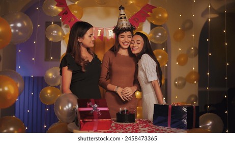 Indian happy beautiful young adult female friends standing sing song excited teen girl burning candles on birthday cake enjoying festive party day celebration together indoor light decor home - Powered by Shutterstock