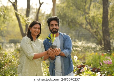 Indian happy couple showing ornamental plant at park. Concept of Save Plants in nature and environment  - Powered by Shutterstock