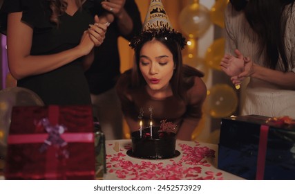 Indian happy excited young adult Unknown female friends standing sing song. beautiful girls enjoying candle burning on birthday cake festive party day celebration together indoor light decor home - Powered by Shutterstock