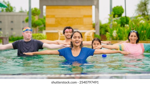 Indian happy extended family standing together in swimming pool doing warm up workout exercise. Smiling older parents with children enjoy sunny day spend time have fun joy outdoor modern resort hotel - Powered by Shutterstock