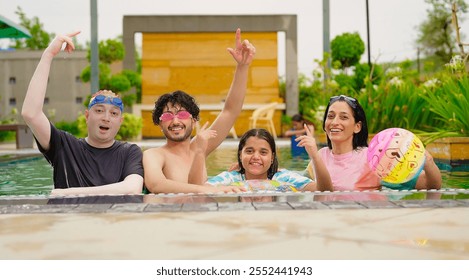 Indian happy extended family standing in swimming pool edge make fun joy look camera enjoy holiday trip resort park picnic. Smiling old senior parent with cute children spend day time outdoor together - Powered by Shutterstock