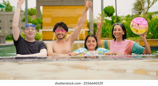 Indian happy extended family standing in swimming pool edge make fun joy look camera enjoy holiday trip resort park picnic. Smiling old senior parent with cute children spend day time outdoor together - Powered by Shutterstock