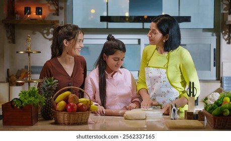 Indian happy mother with cute daughter rolling raw dough together teach baking cookies in modern kitchen house. Carefree young adult mom girl kid child learn cooking homemade bakery food indoor home - Powered by Shutterstock