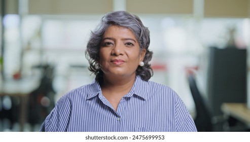 Indian happy old aged business woman sitting look camera do work talk distant client on video call indoor office. Head shot portrait elder adult expert female employee speak conference at job place - Powered by Shutterstock