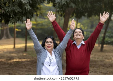 Indian happy senior couple spreading hands at park. old couple looking at the sky while spending time together, relationship and people concept. Senior Living Retirement and Pension Plans Concept - Powered by Shutterstock