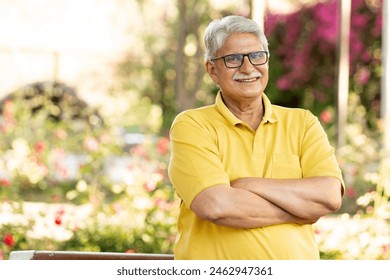 Indian happy senior man feels freedom, fun and spending leisure time while looking at the camera at the park after retirement - Powered by Shutterstock