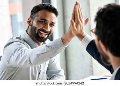 Indian happy smiling multiracial professional ceo businessman giving highfive to business partner after financial acquisition bank bargain contract at office. High five concept. Over shoulder view. - Shutterstock ID 2024994242