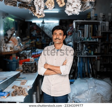 Indian hardware shop owner, salesman, vendor or seller showing products, customer service concept