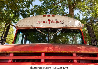 Indian Head, MD, USA,  09/19/2020: Bug eye view of A red old rusty  IC school bus which is later decommissioned and then used as a church bus. The School bus text got replaced with Jesus Saves text.