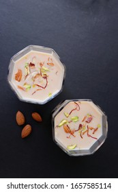 Indian Holi Or Kojagiri Festival Drink Thandai Or Masala Milk. It Is An Indian Cold Drink Prepared With A Mixture Of Milk, Dry Fruits & Sugar. Garnished With Almonds, Pistachio & Saffron. Copy Space.