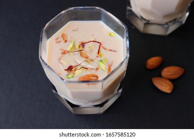 Indian Holi Or Kojagiri Festival Drink Thandai Or Masala Milk. It Is An Indian Cold Drink Prepared With A Mixture Of Milk, Dry Fruits & Sugar. Garnished With Almonds, Pistachio & Saffron. Copy Space.