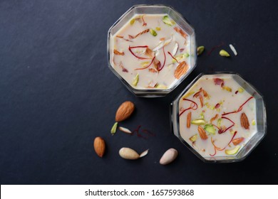 Indian Holi Or Kojagiri Festival Drink Thandai Or Masala Milk. It Is An Indian Cold Drink Prepared With A Mixture Of Milk, Dry Fruits & Sugar. Garnished With Almonds, Pistachio & Saffron. Copy Space.