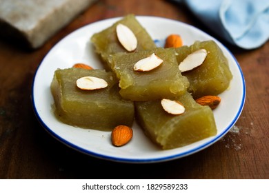 Indian Homemade Dessert Wheat Halwa Garnished With Almond On A Colorful Background