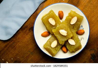 Indian Homemade Dessert Wheat Halwa Garnished With Badam On A Colorful Background
