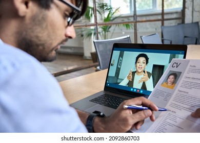 Indian human resource manager holding cv having virtual job interview conversation with remote female candidate during distant business video call on laptop computer. Online recruitment concept.