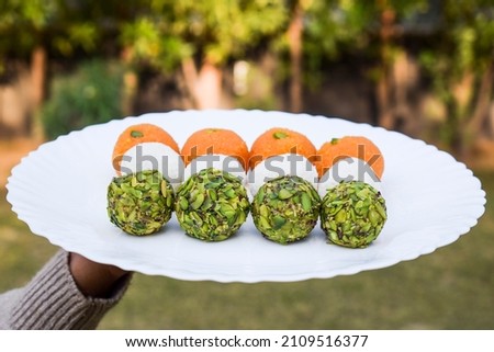 Indian Independence day 15 August, Republic day of India 26 January concepts of tricolour food Three colours of Ladoo or Laddus in hand. orange saffron, coconut white and pista green