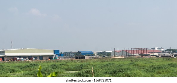 Indian Industrial Area Landscape. Industry Surrounded By Rural Agricultural Field And Green Summer Meadow. A Beautiful Non-urban Scenic Environment Of Rural Countryside Of India, South Asia Pacific.