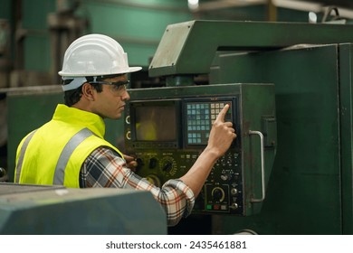 indian industrial worker beard man with helmet controlling cnc machine or maintenance in industry factory . labor male asian india Engineer standing repairing and fixing monitor in manufacturing. - Powered by Shutterstock