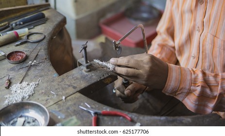 Indian Jeweler Making An Oriental Jewelry In Workshop. Handmade Traditional Jewel Manufacturing In Jaipur (Rajasthan). Jewelry Manufacturing Process In India. Indian Silver And Gold Jewel And Gems 