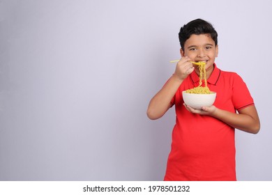 Indian Kid Or Boy Eating Noodles.