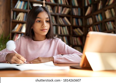 Indian latin girl school pupil distance learning online at remote virtual class with teacher by video conference call, watching webinar, zoom meeting lesson on digital tablet at home, in classroom. - Shutterstock ID 1814263607