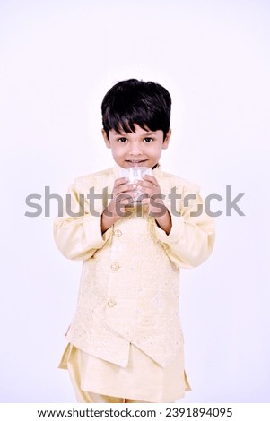 Indian little boy holding milk in hand onwhite background