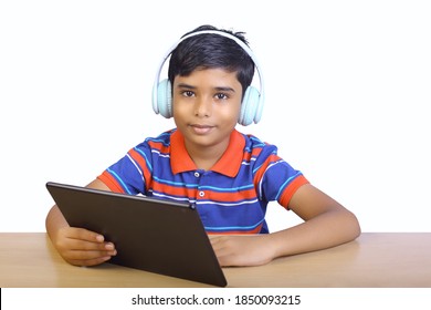 Indian Little Boy Using Digital Tablet While Attending The Online Classes At Home