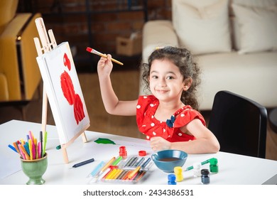 Indian little girl or kid Painting On Easel using brush and paint - Powered by Shutterstock