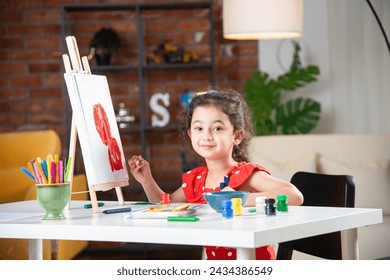 Indian little girl or kid Painting On Easel using brush and paint - Powered by Shutterstock