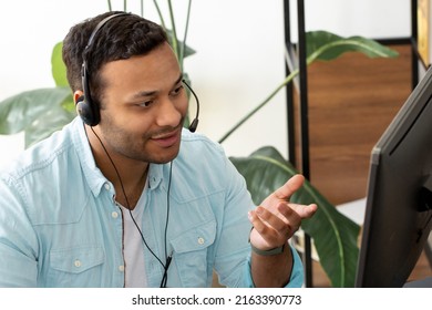 Indian Male Call Center Agent With Headset Working On Support Hotline While Sitting In Modern Office Portrait Of Asian Help Desk Worker In Conversation With A Client Through Headset Using Video Call