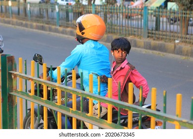 An Indian Male Child Pillion Rider Looking Back Wearing Ear Phones. Bangalore. Karnataka, India. Nov 2018