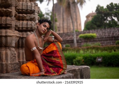 Indian male dancer posing in front of Chitrakarini Temple, Bhubaneswar, Odisha. Indian dance odissi