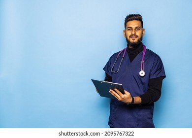 A indian male doctor holding a blank clipboard and looking at him. Surgeon concept.