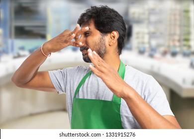 Indian Male Employee At Fish Market Or Supermarket Making Bad Smell Gesture And Disgusted Expression As Holding Nose