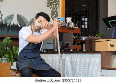 Indian male employee sit and resting after a long day at work. Small business owner coffee shop tired after mopping the floor, waitres secretly fell asleep after working hard. Restaurant owner concept - Powered by Shutterstock