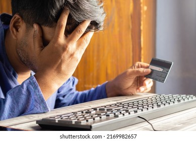 An Indian Male Holding Head With Credit Or Debit Card In Other Hand After Online Fraud In Front Of Computer