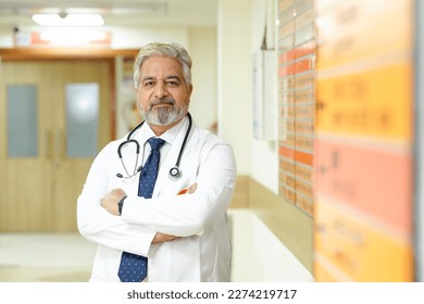 Indian male senior doctor standing at hospital. - Powered by Shutterstock