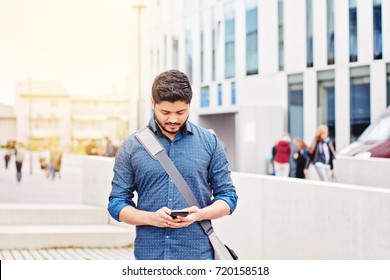 Indian Male Student Texting On Smartphone
