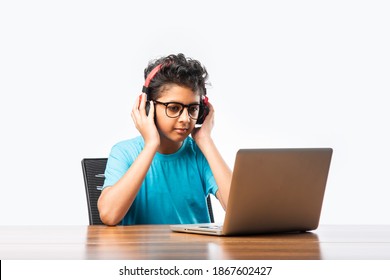Indian male syudent or kid studying online using laptop. Asian child attending online school using computer