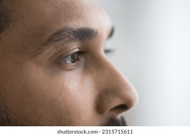 Indian male upper face close up shot. Serious handsome young man looking away. Model, patient promoting eyesight examination, eye care, optic lens, vision correction. Cropped portrait - Powered by Shutterstock