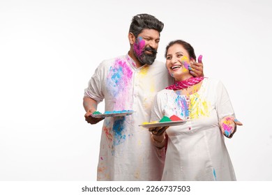 Indian man applying color on woman face and celebrating holi festival. - Powered by Shutterstock