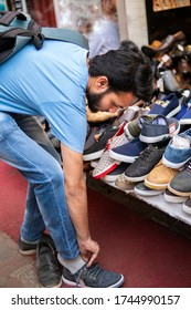 Indian Man Choosing And Buying Shoes Form Store At Street Market. 