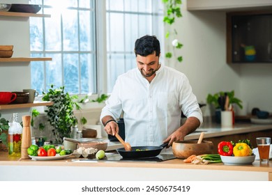 Indian man cooking in kitchen alone - Powered by Shutterstock