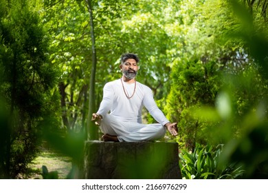 Indian Man Doing Yoga Meditation Exercise In The Green Forest Nature. Fitness And Healthy Lifestyle.