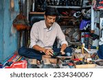 Indian man repairs shoes on the street also called shoemaker, cobbler or mochi