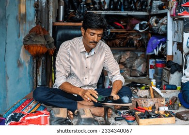 Indian man repairs shoes on the street also called shoemaker, cobbler or mochi - Powered by Shutterstock